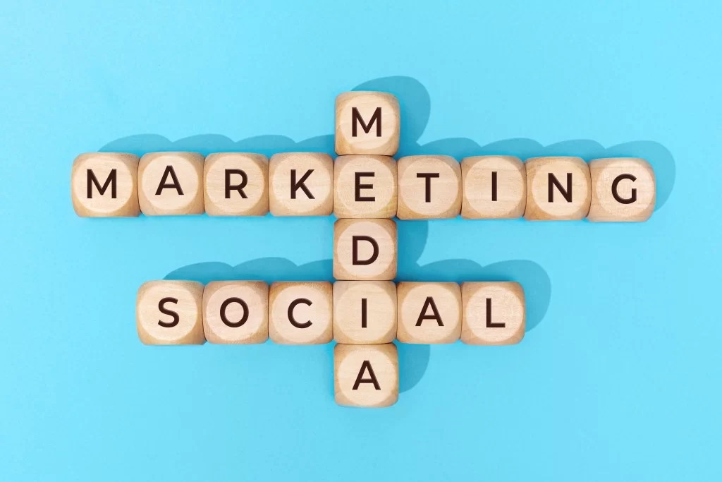 Social media marketing words on wooden blocks on blue background | digital marketing trends 2022 by 702 pros